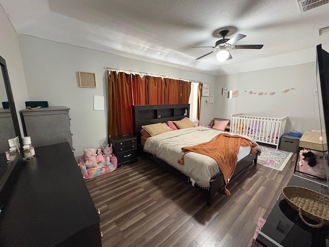 bedroom featuring dark wood-type flooring, visible vents, and ceiling fan