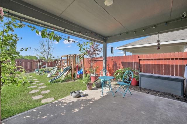 view of patio with a fenced backyard and a playground