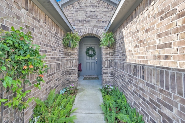view of exterior entry featuring brick siding