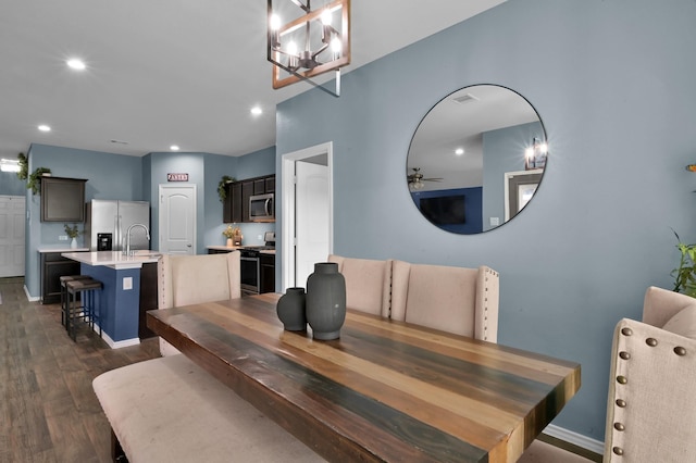 dining space featuring dark wood-style flooring, baseboards, visible vents, recessed lighting, and ceiling fan with notable chandelier