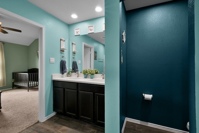 bathroom with ceiling fan, toilet, wood finished floors, and a sink