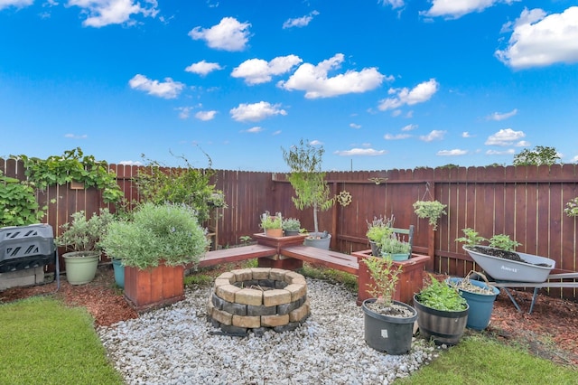 view of yard featuring a fire pit and a fenced backyard