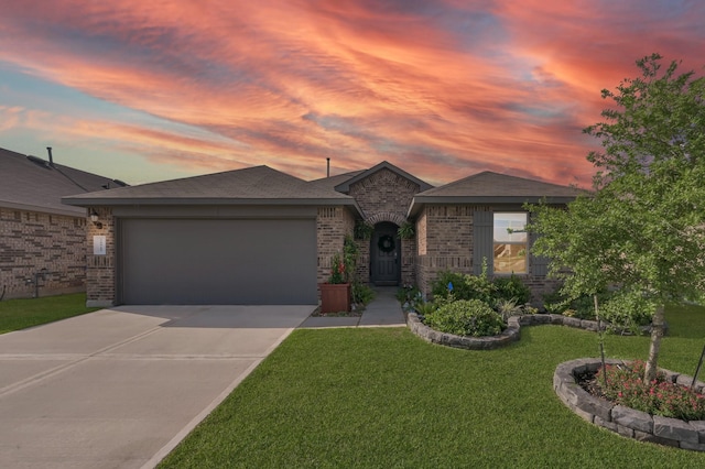 view of front of property with brick siding, an attached garage, a front yard, and concrete driveway