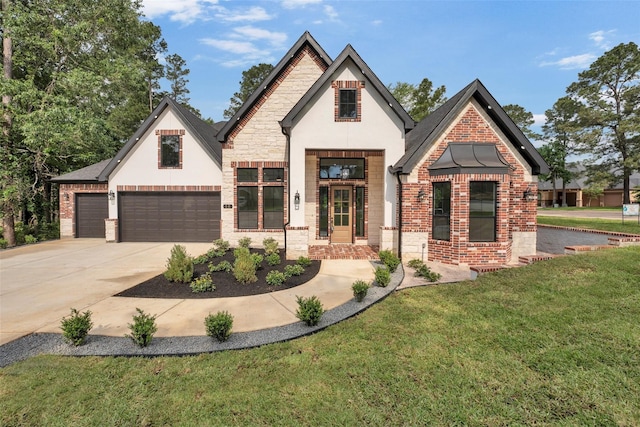 view of front of house featuring driveway, stone siding, brick siding, an attached garage, and a front yard