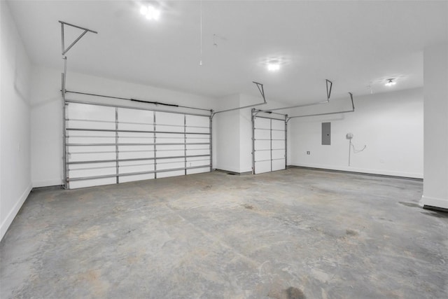 garage featuring electric panel and baseboards