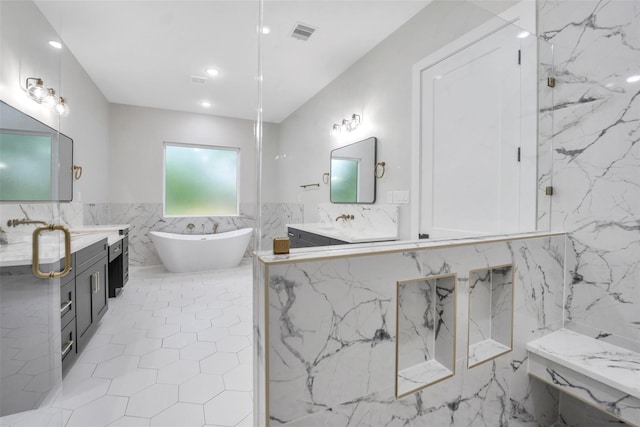 bathroom with tile walls, a soaking tub, vanity, and wainscoting