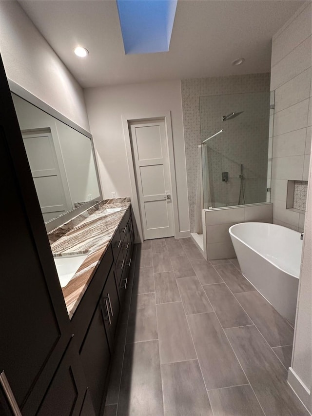 2409 Webster St, Houston, TX 77003 - bathroom with a tile shower, double vanity, a freestanding bath, recessed lighting, and a skylight