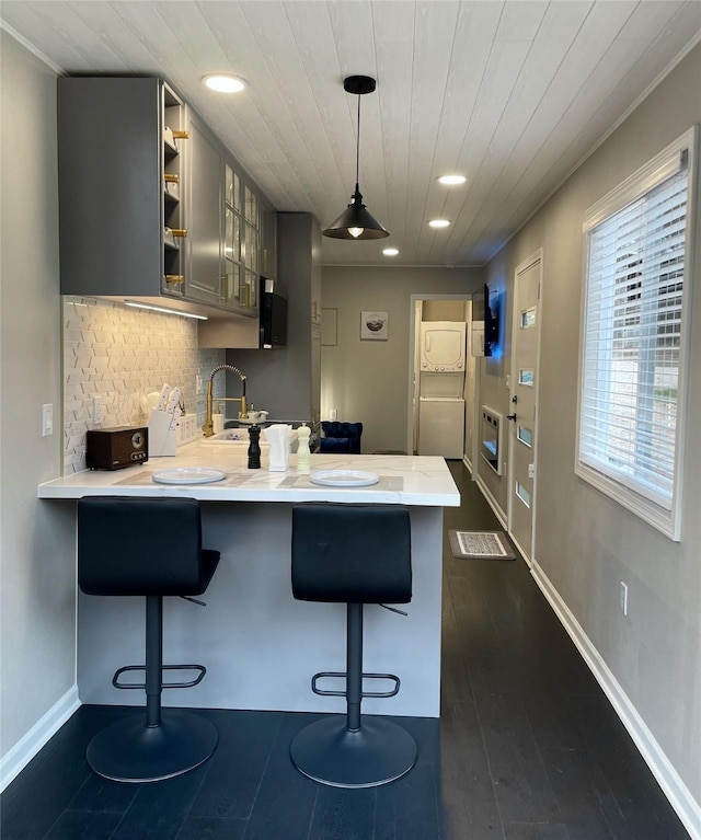 kitchen featuring a peninsula, wooden ceiling, light countertops, and a kitchen breakfast bar