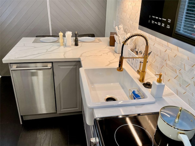 bathroom with backsplash, wood finished floors, and a sink