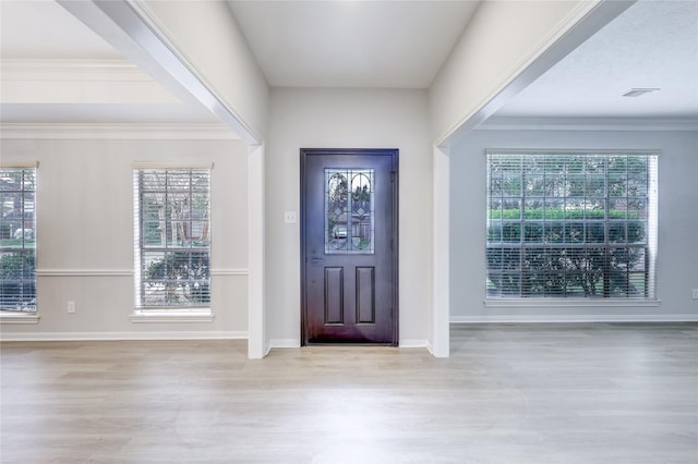 entryway with visible vents, wood finished floors, baseboards, and a healthy amount of sunlight