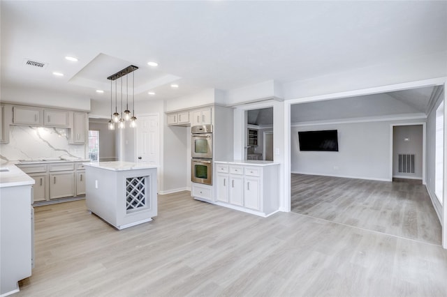 kitchen with baseboards, visible vents, open floor plan, light wood-style floors, and double oven