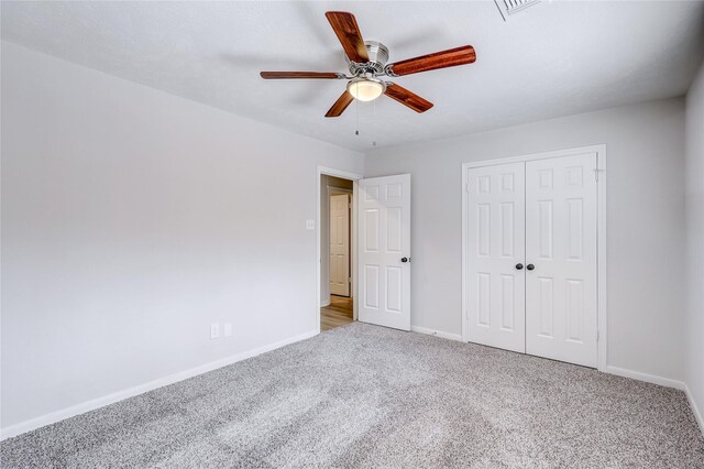 unfurnished bedroom with carpet, a closet, baseboards, and a ceiling fan