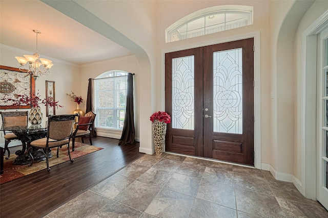 20322 Fossil Valley Ln, Cypress, TX 77433 - foyer entrance with a chandelier, french doors, arched walkways, stone tile floors, and crown molding