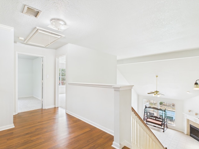 hallway with attic access, a wealth of natural light, visible vents, and an upstairs landing