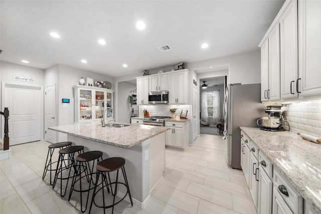 18203 Octavio Frias Trl, Atascocita, TX 77044 - kitchen featuring a sink, stainless steel appliances, a kitchen breakfast bar, visible vents, and decorative backsplash