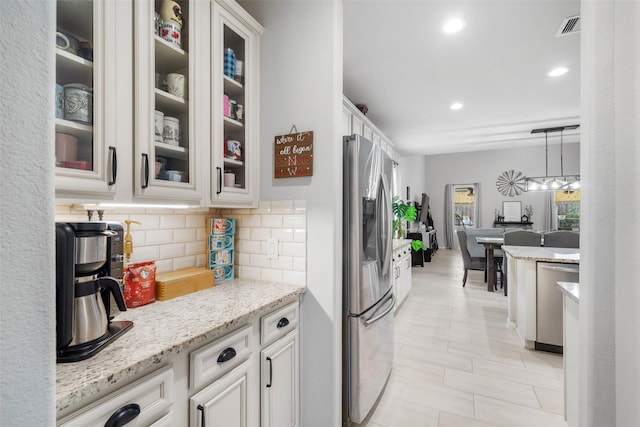 18203 Octavio Frias Trl, Atascocita, TX 77044 - kitchen with stainless steel appliances, tasteful backsplash, visible vents, and glass insert cabinets