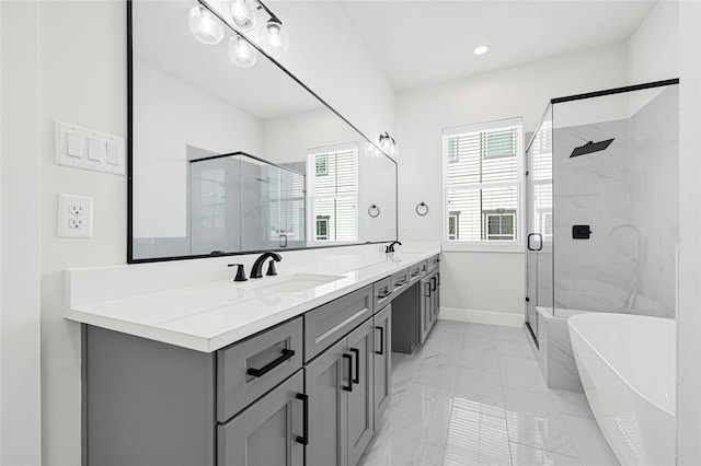 full bath with a shower stall, marble finish floor, a freestanding bath, double vanity, and a sink
