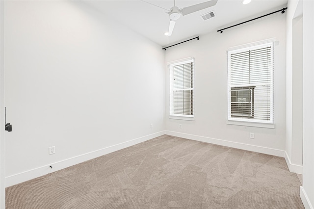 unfurnished room with light carpet, baseboards, visible vents, and ceiling fan
