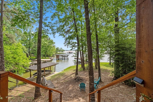 view of playground featuring a dock and a water view