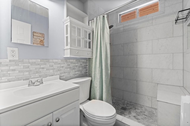 bathroom featuring tile walls, vanity, toilet, and tiled shower