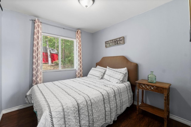 bedroom with wood finished floors and baseboards