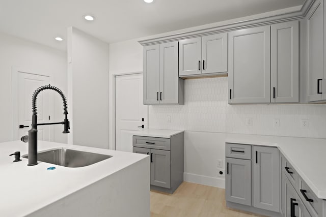 8131 Woodward St, Houston, TX 77051 - kitchen featuring gray cabinets, light wood-type flooring, decorative backsplash, recessed lighting, and light countertops