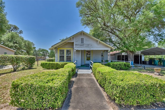 bungalow-style home with a porch and a detached carport