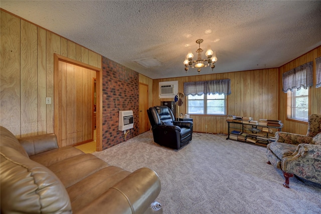 living room featuring a wall unit AC, carpet, a notable chandelier, heating unit, and wood walls