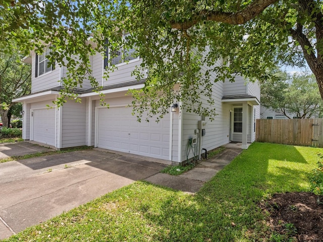 view of home's exterior with a lawn, an attached garage, fence, and concrete driveway