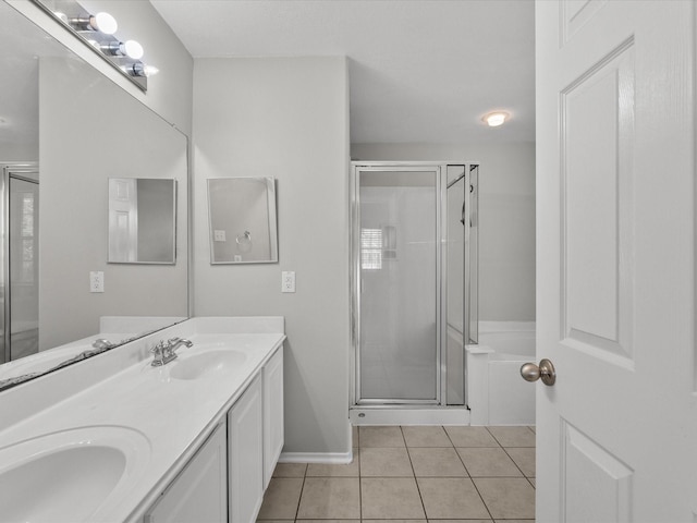 full bathroom featuring a sink, double vanity, baseboards, tile patterned flooring, and a shower stall