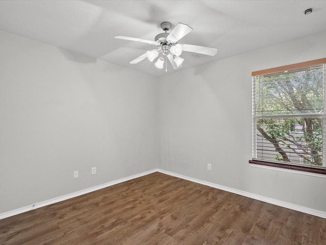 spare room with wood finished floors, baseboards, and ceiling fan