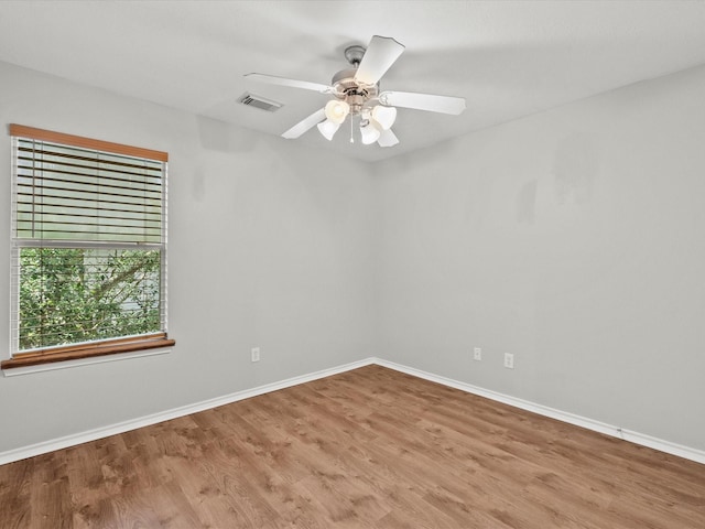 spare room with baseboards, visible vents, and light wood finished floors