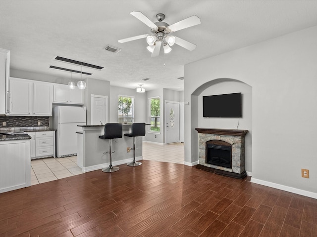 kitchen with dark countertops, light wood-type flooring, white cabinetry, visible vents, and freestanding refrigerator