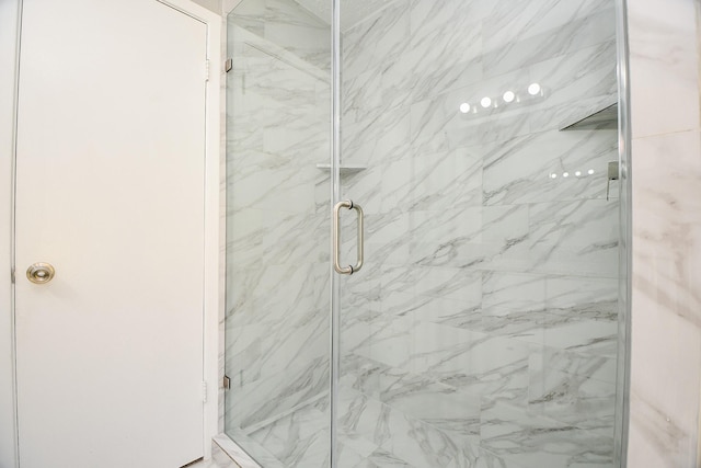 bathroom featuring a marble finish shower