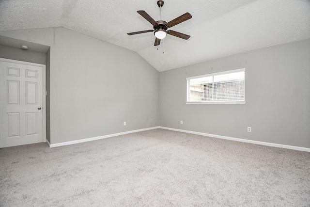 spare room with lofted ceiling, baseboards, and carpet floors
