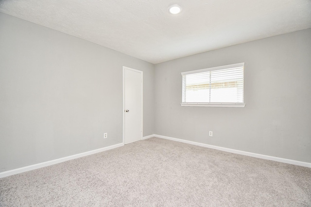 carpeted empty room with baseboards