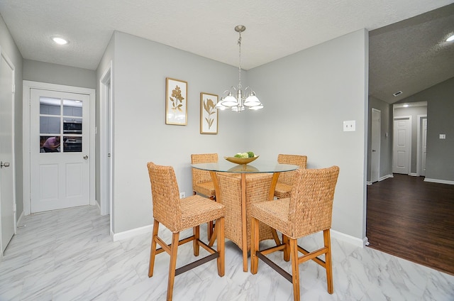 dining room with a chandelier, a textured ceiling, marble finish floor, and baseboards