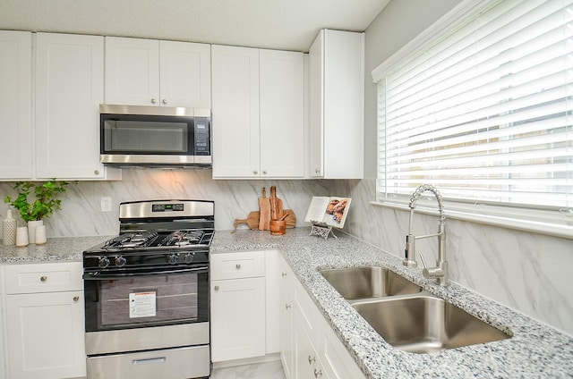 kitchen with white cabinets, appliances with stainless steel finishes, and a sink