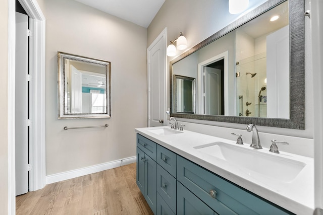 6 Compass Cir, Galveston, TX 77554 - bathroom with a stall shower, wood finished floors, double vanity, and a sink