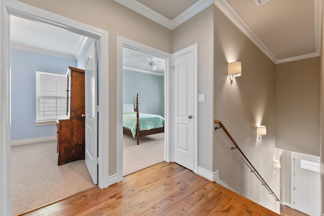 6 Compass Cir, Galveston, TX 77554 - hall with crown molding, light wood finished floors, an upstairs landing, and baseboards