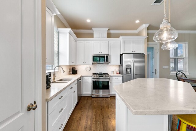 6 Compass Cir, Galveston, TX 77554 - kitchen featuring ornamental molding, a sink, appliances with stainless steel finishes, and a healthy amount of sunlight
