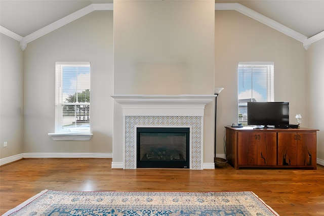 6 Compass Cir, Galveston, TX 77554 - unfurnished living room featuring wood finished floors, a tile fireplace, ornamental molding, and vaulted ceiling