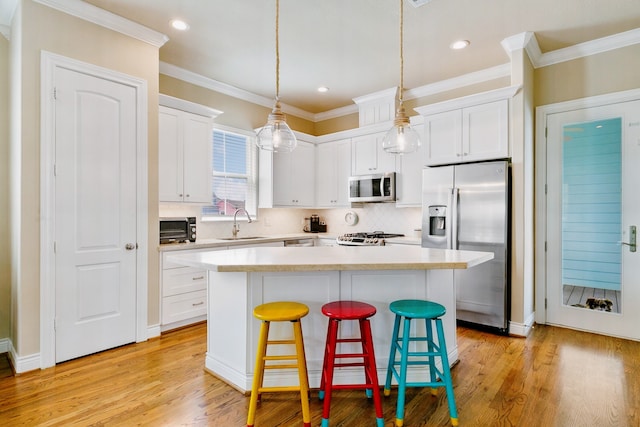 6 Compass Cir, Galveston, TX 77554 - kitchen featuring stainless steel appliances, a kitchen island, white cabinets, and a sink