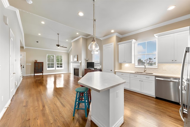6 Compass Cir, Galveston, TX 77554 - kitchen with a sink, appliances with stainless steel finishes, a center island, a ceiling fan, and backsplash