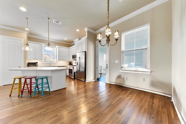 6 Compass Cir, Galveston, TX 77554 - kitchen with stainless steel appliances, light countertops, ornamental molding, a sink, and visible vents