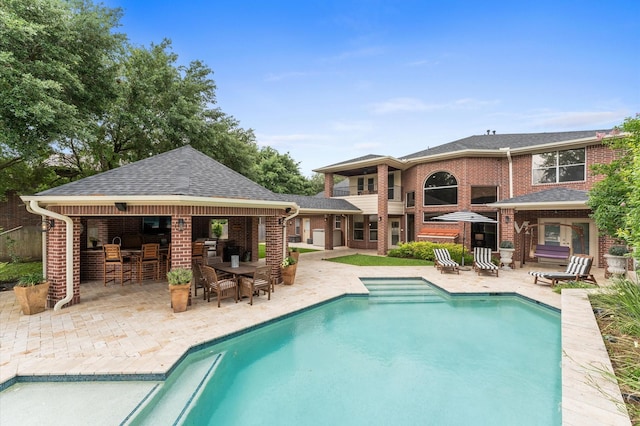 pool with outdoor dry bar and a patio