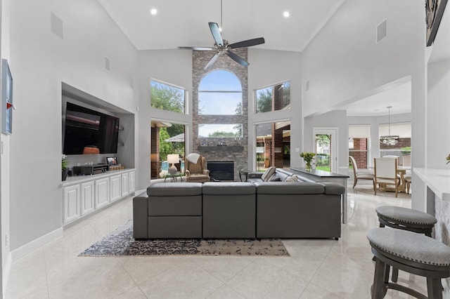 living room with ceiling fan, a large fireplace, recessed lighting, light tile patterned floors, and a towering ceiling