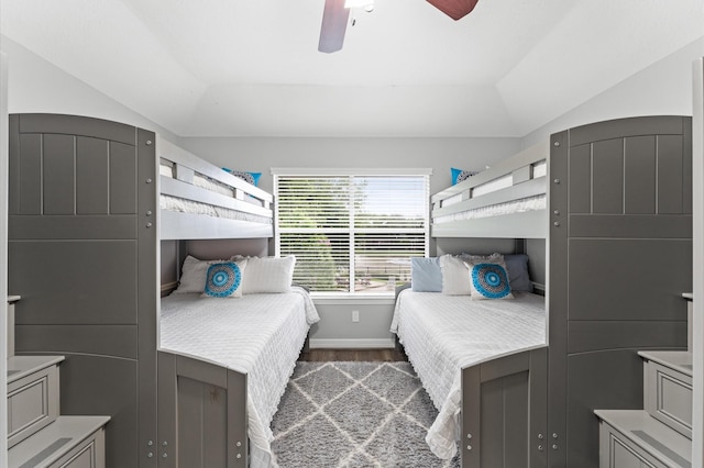 bedroom with baseboards, ceiling fan, wood finished floors, and lofted ceiling