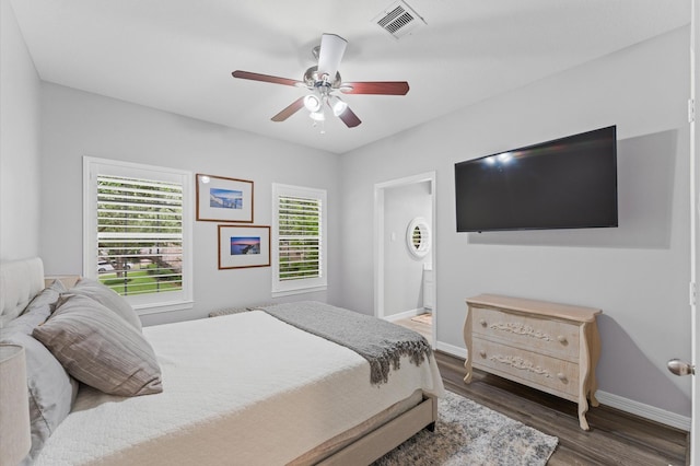 bedroom with visible vents, a ceiling fan, baseboards, and wood finished floors