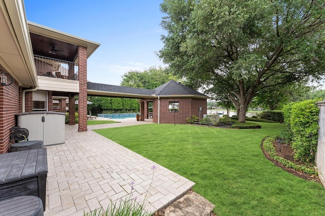 view of yard with a patio, a ceiling fan, and an outdoor pool